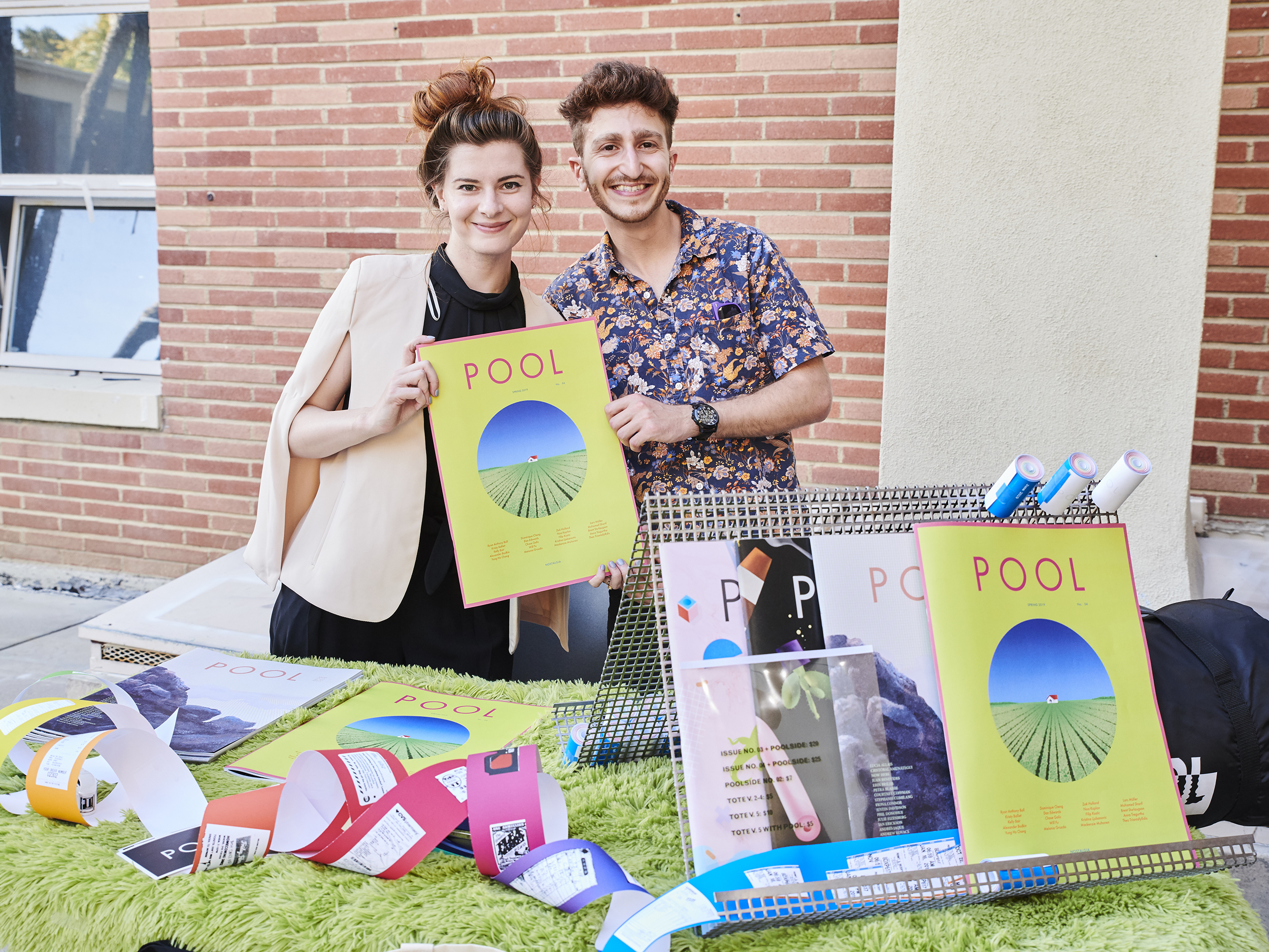 Students standing behind a table holding up the latest copy of POOL