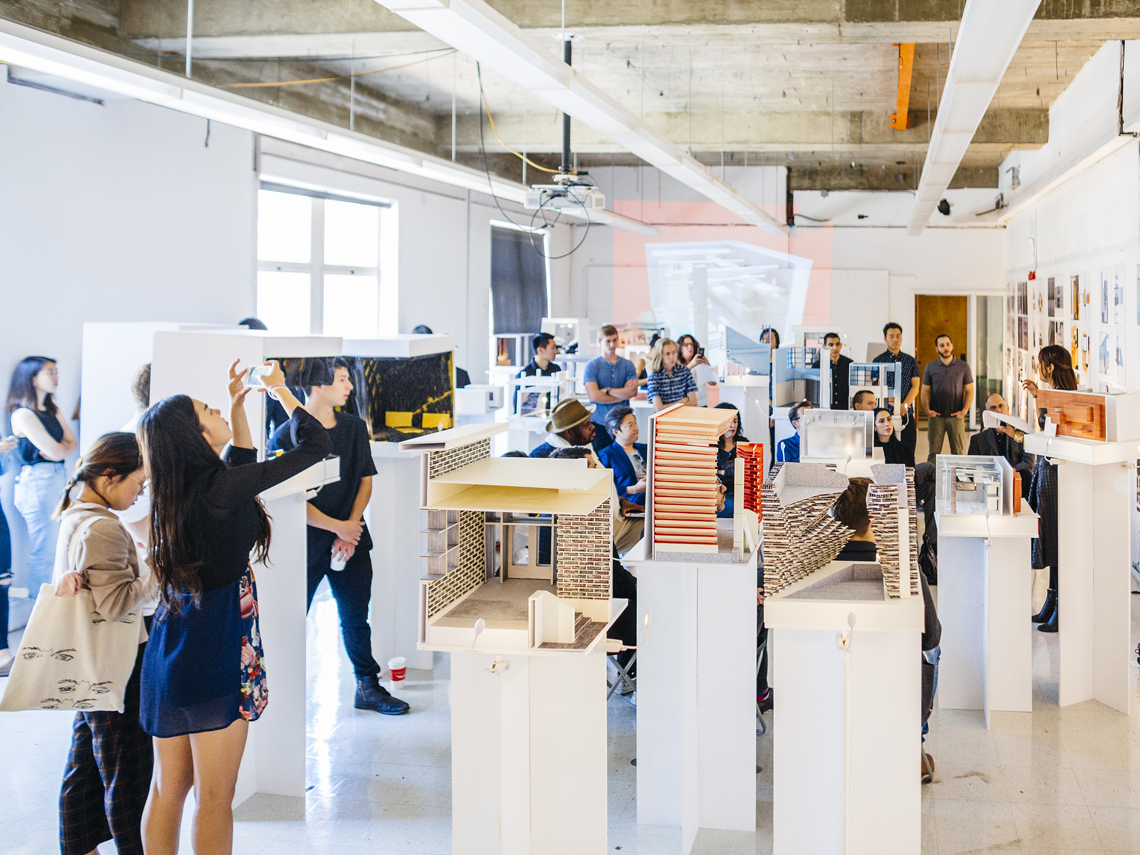 A group of students gathered around a review with models all around the room