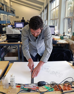 Student leaning over a desk working on a project