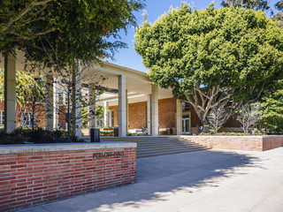 Exterior shot of Perloff Hall, a red brick building surrounded by trees