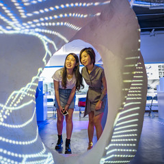 Two female students looking through an interactive exhibition