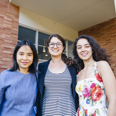 Two female students with a company representative from CO Architects, who supported a scholarship