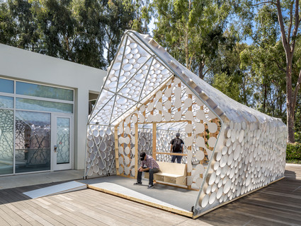 Photo of the exterior of BI(h)OME, a speculative Accessory Dwelling Unit framed with two-by-fours and bent metal poles and wrapped in translucent plastic sheeting.