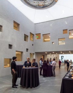 Interior view of the Terasaki Research Institute in Los Angeles. A cluster of people are standing in an atrium which is enclosed with a translucent double membrane structure in the roof.