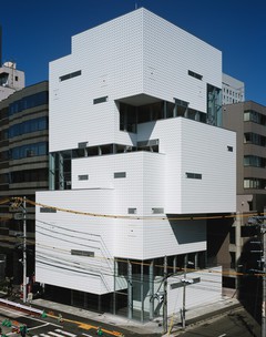 Image of a white angular building on the corner of a street in Sendai, Japan.