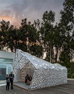 Image of BI(h)OME, a lightweight Accessory Dwelling Unit framed with two-by-fours and bent metal poles and wrapped in translucent plastic sheeting.