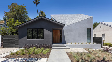 Image of a residential house against a bright blue sky with an angled roof