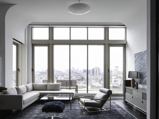 Image of a living room in a penthouse with curved ceilings looking out over the NYC skyline