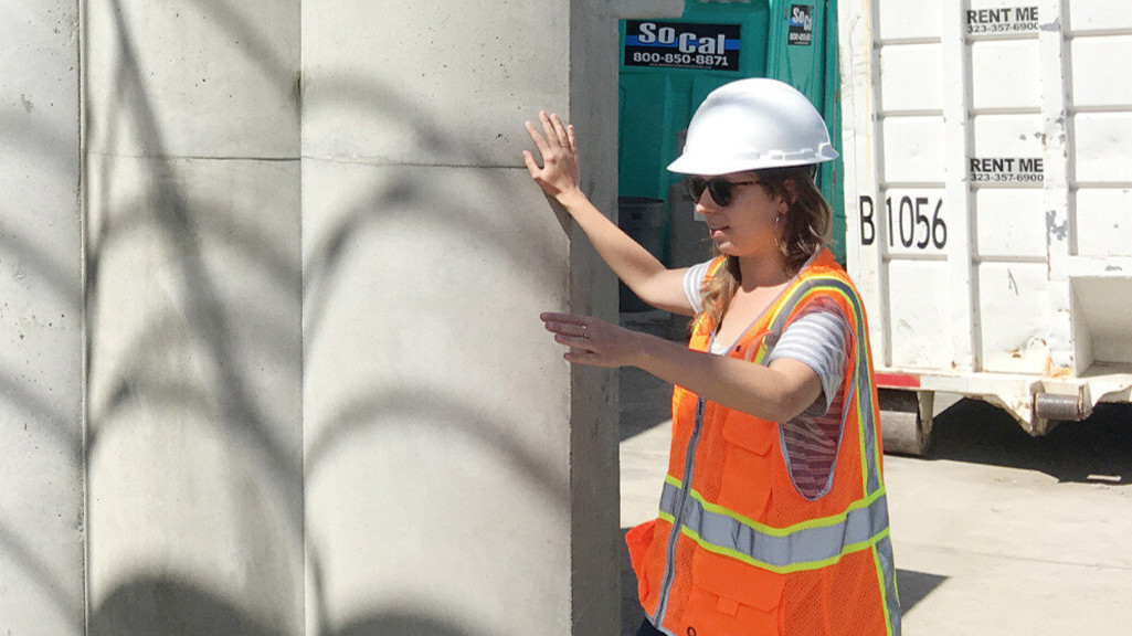 Image of a young female in a high-vis jacket at a building site