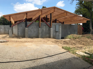 Image of a house under construction with a wood roof and concrete walls