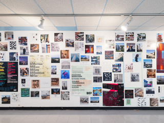 A photograph showing a series of architectural images, each on a square page, assembled across a wall like pixels