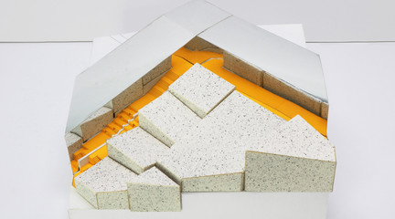 Physical model with white and mirrored surfaces and a yellow staircase.