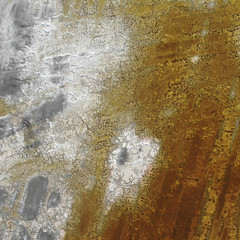 Aerial photograph of dried lake bed with predominantly blue and white coloration on the left and rust on the right.
