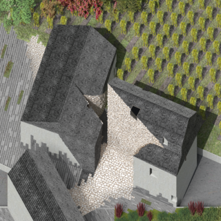 Black roofed building with interior stone courtyard set in a vineyard setting.
