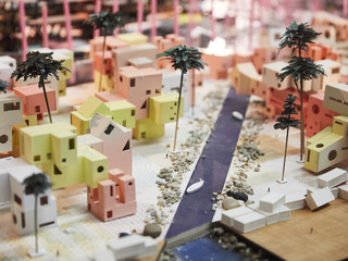 Image of a final student model representing the reimagined island of Tuvalu, with small house, palm trees and a waterway running through.