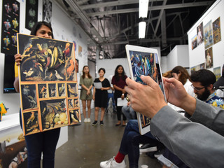 Image of a student holding up an image in front of an iPad showing augmented reality